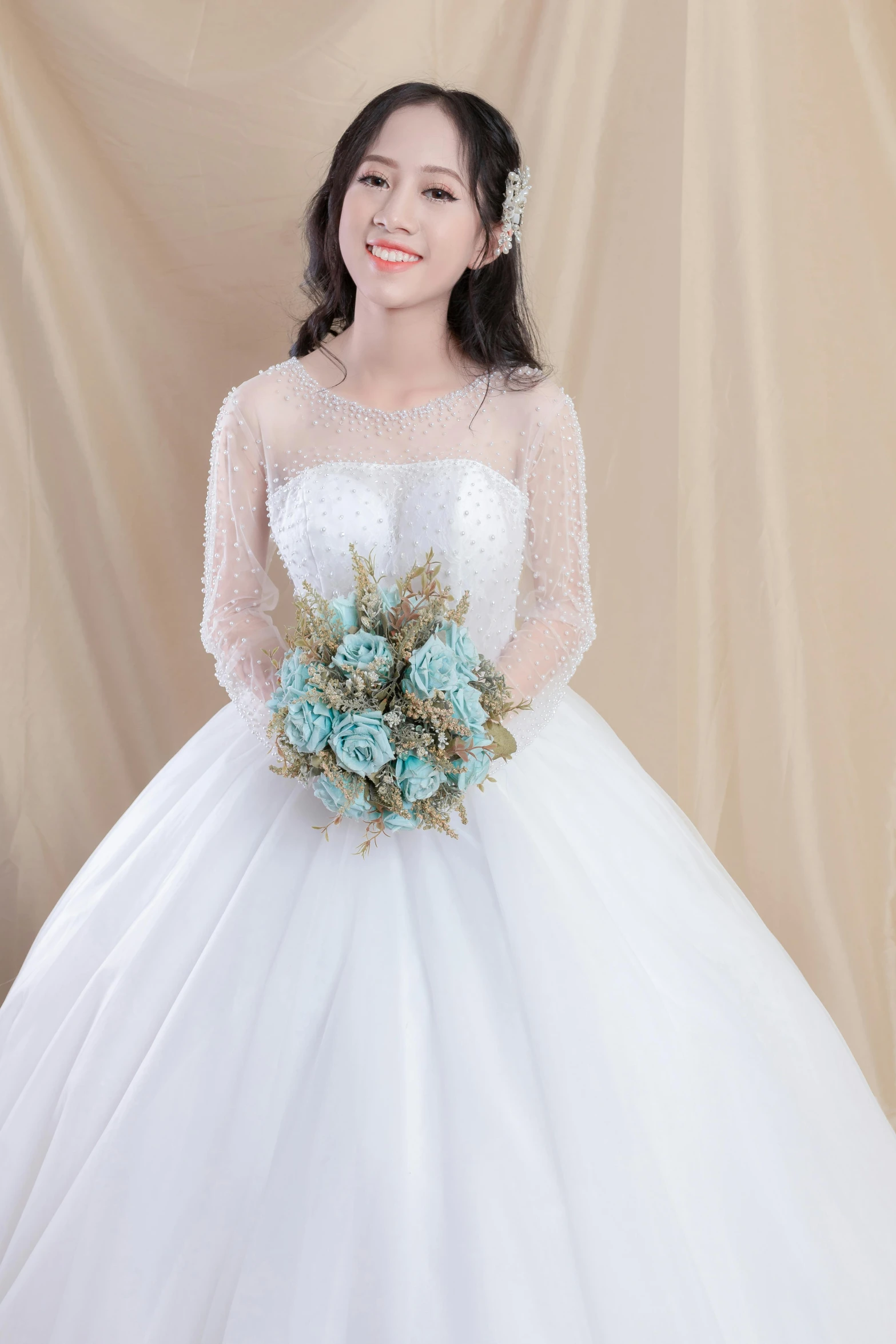 an asian bride in a gown with flowers on her bouquet