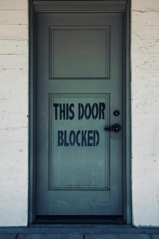 a door with an old sign that reads this door blocked