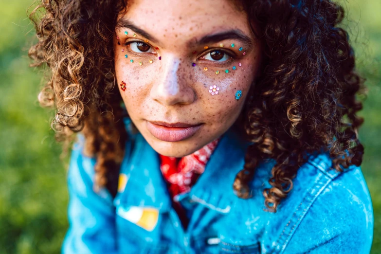 an adorable girl with painted faces and nose piercings