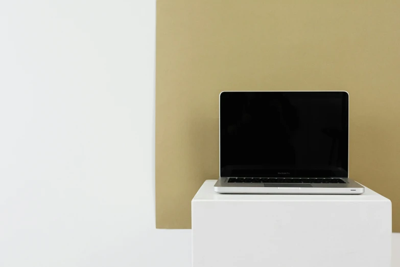 a laptop is sitting on a small pedestal