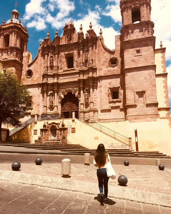 a person stands in front of a stone castle