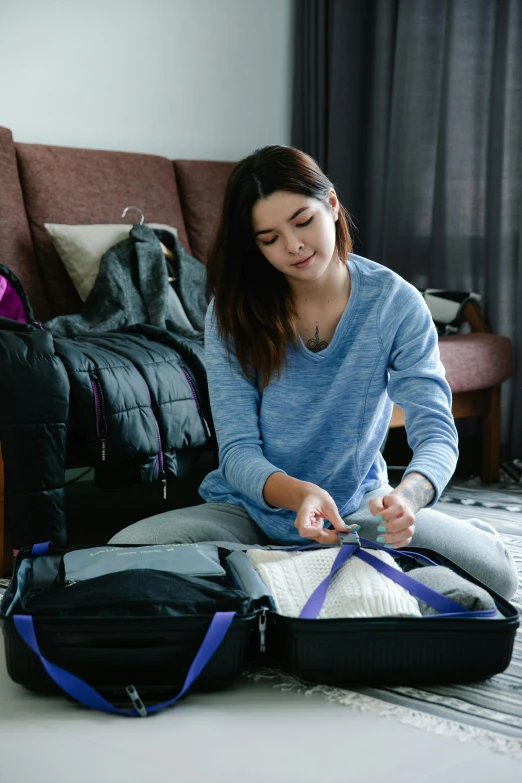 woman sitting on floor looking at small bag