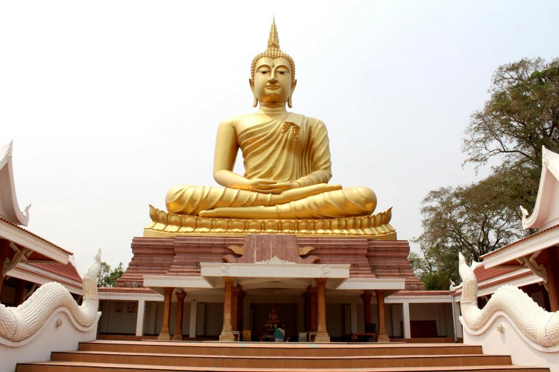 the buddha statue is sitting on a platform near stairs