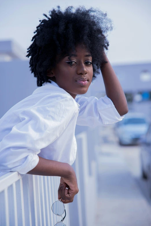 a woman wearing a white shirt leaning on a white rail