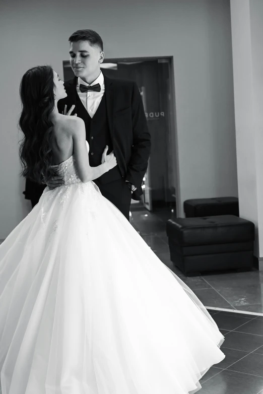 a young couple are standing together in their dress