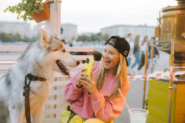 a girl and her dog sitting on a wooden chair outside