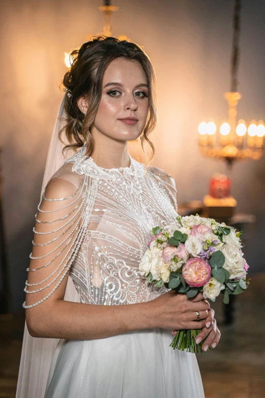 a woman in a wedding gown standing holding a bouquet