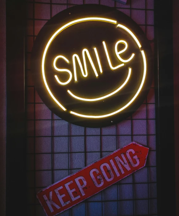 a smile sign hanging on the side of a wall