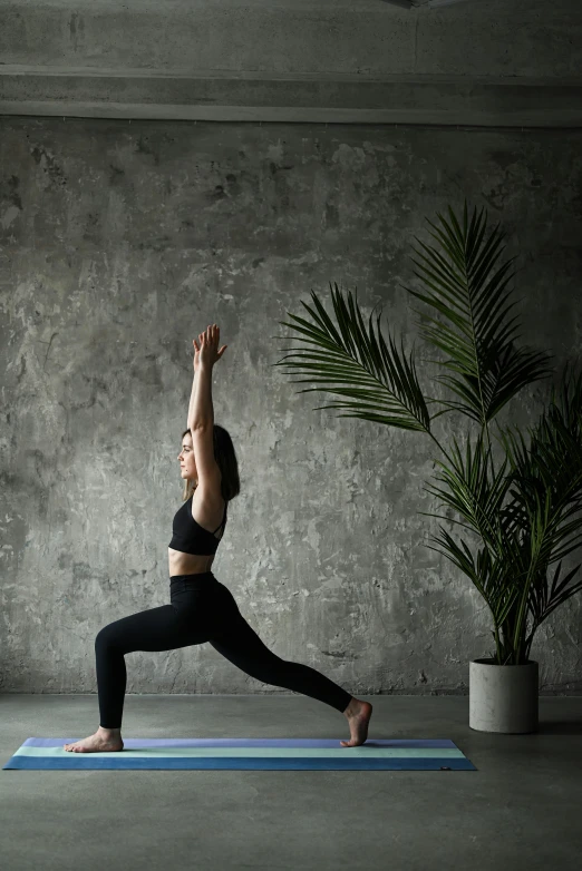 a woman practices a yoga pose in the middle of the room