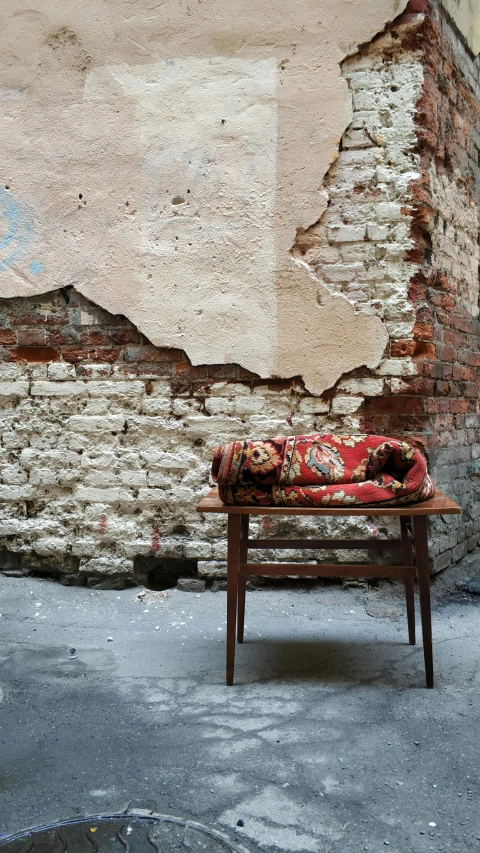 an old wooden bench and cover sit against a ed down building