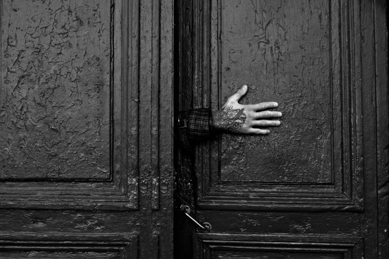 a hand coming out of a door, with her arm outstretched