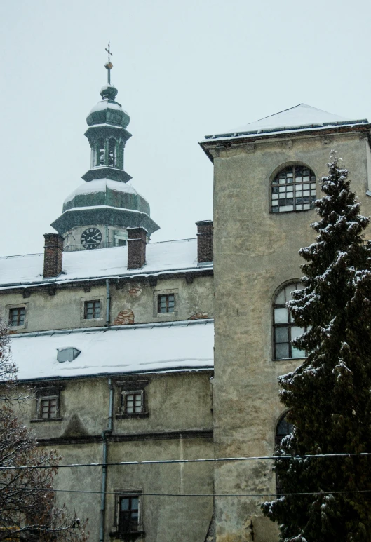snow covers the tops of an older building