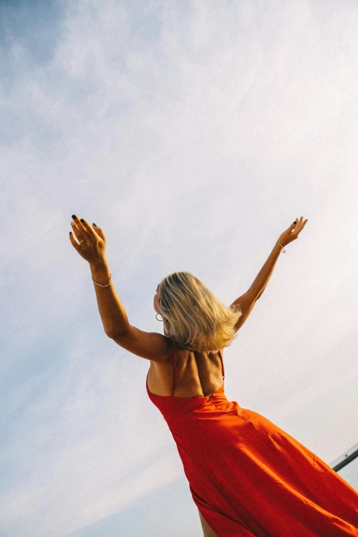 the woman is wearing a red dress and flying a kite