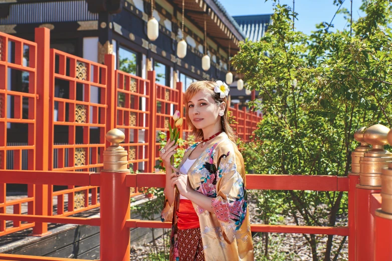 an asian woman holding flowers in her hands