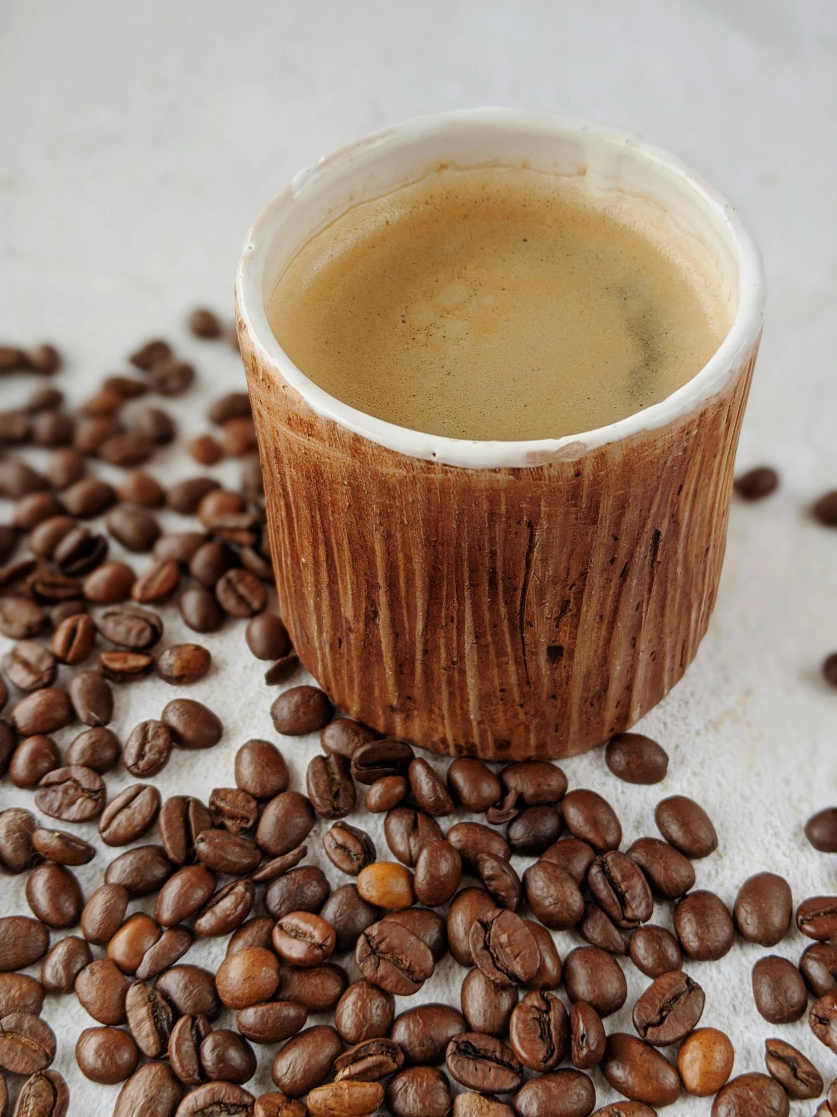 a cup of coffee next to some beans