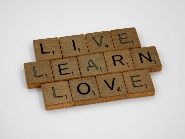 three scrabble tiles spelling live, learn, love