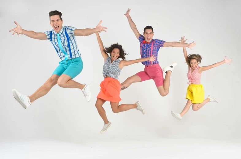 four people posing with their hands in the air