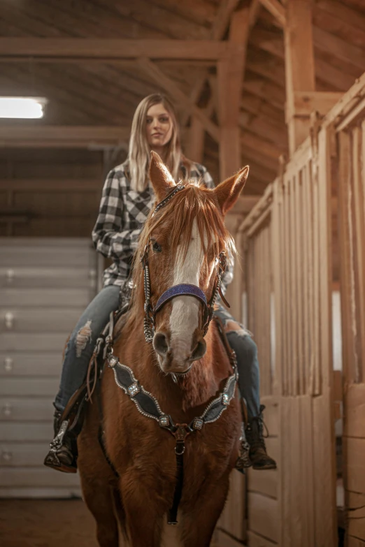 the women are riding horses in a stable