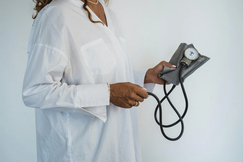 a woman in white blouse holding a grey machine