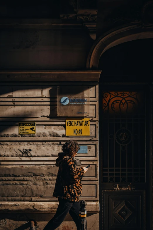 a person walking next to a building with two street signs attached to it