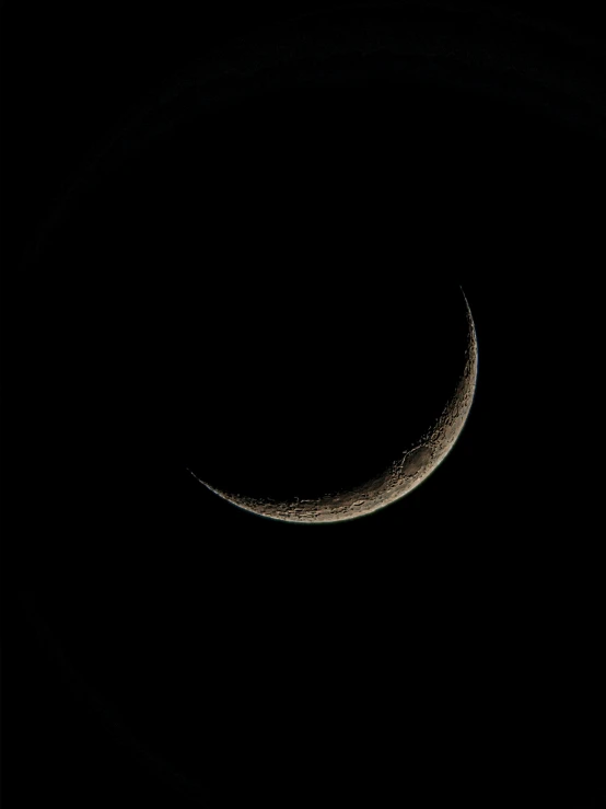 the crescent of a moon is seen in the dark