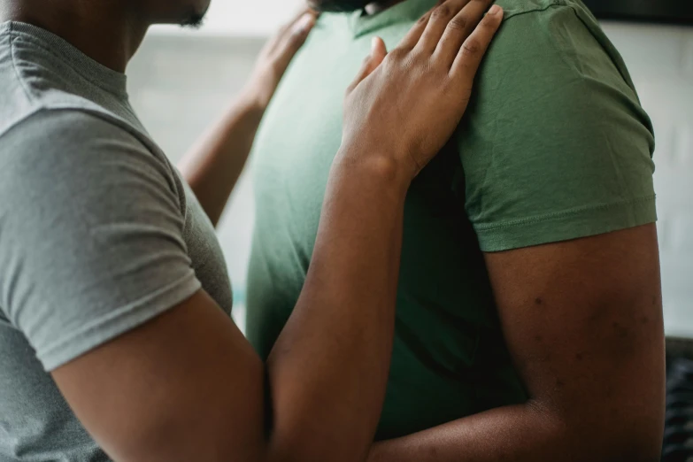 a man hugs the face of a woman while she is wearing green