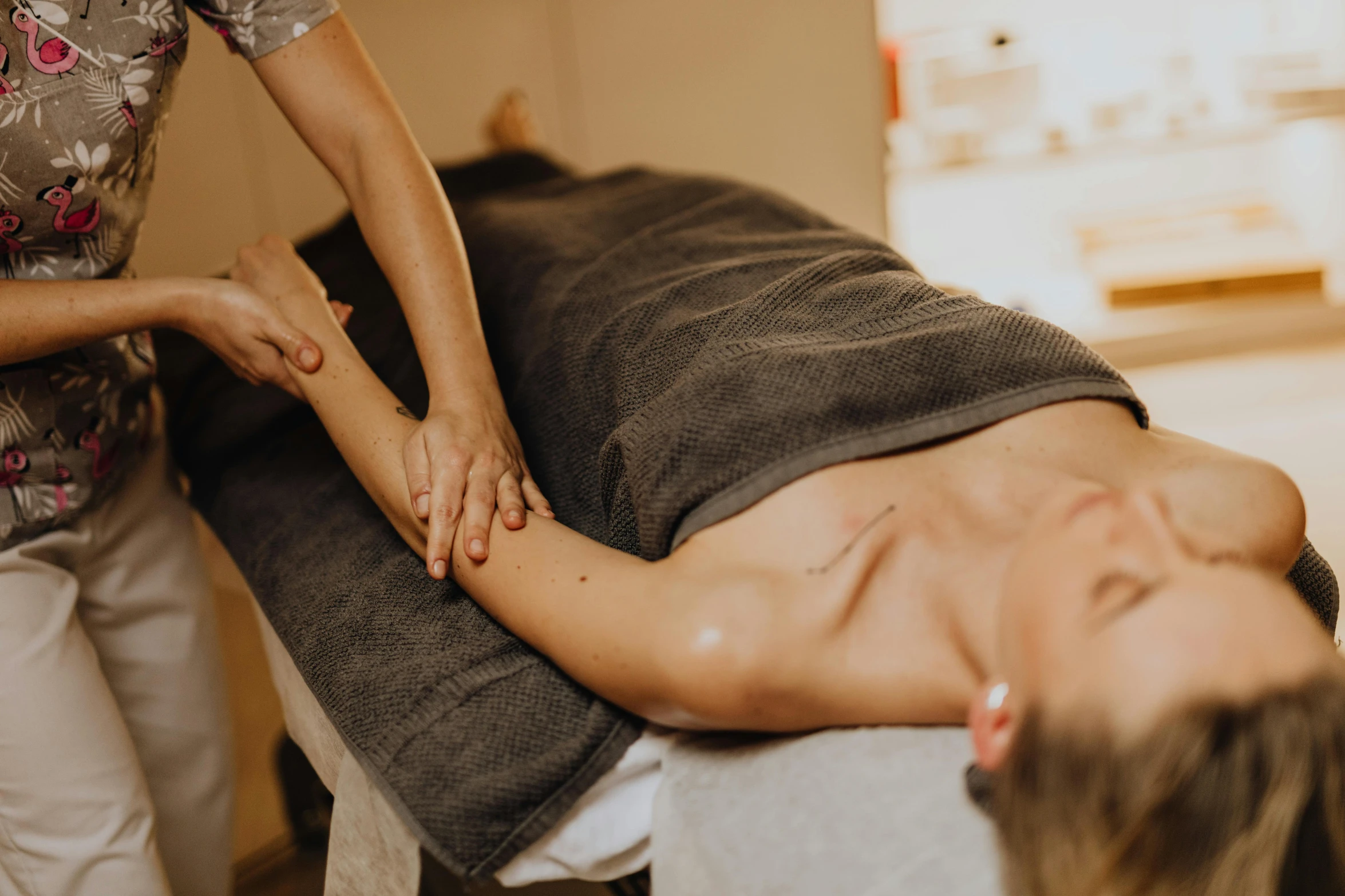 a person being massaged on another person in a room