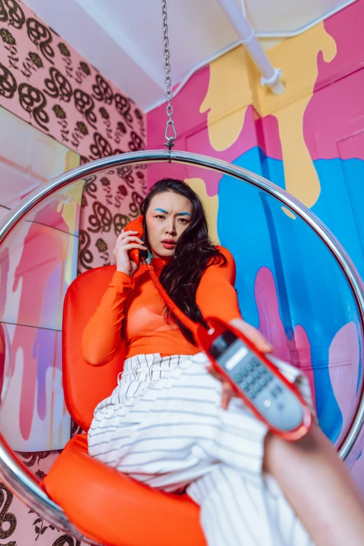 a woman in an orange shirt laying in a large metal chair