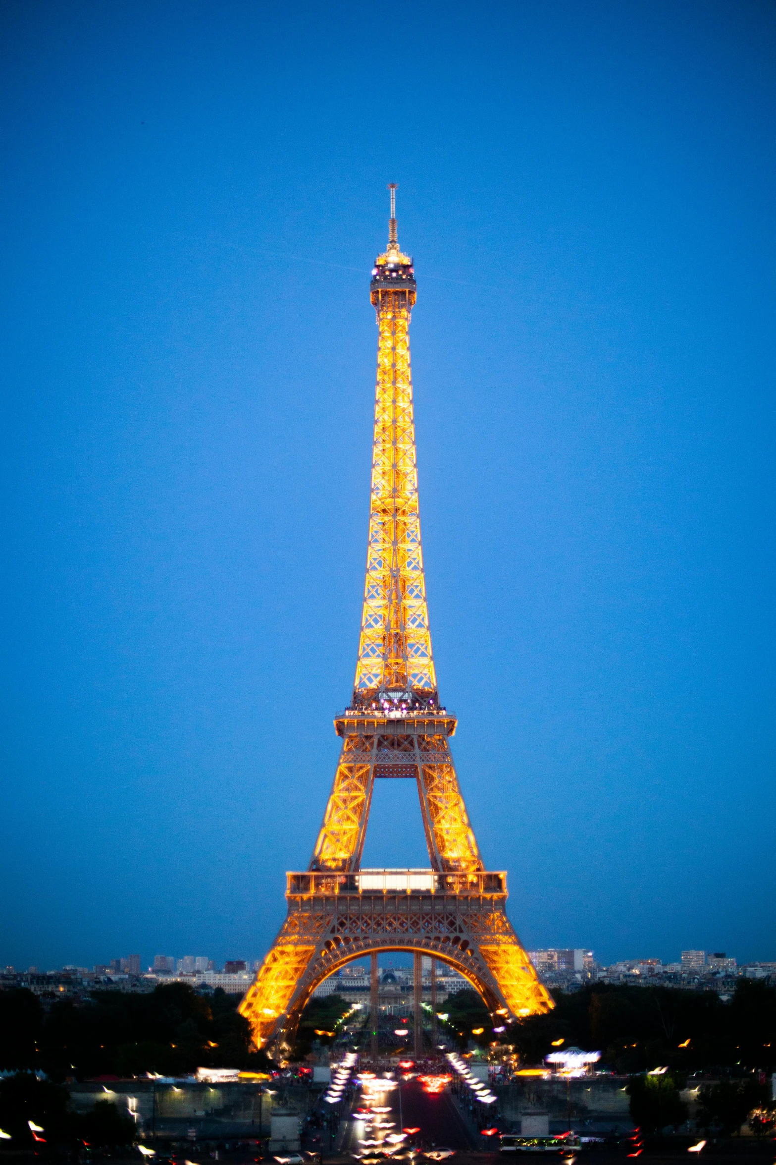 the eiffel tower at night lit up in all it's yellow glory