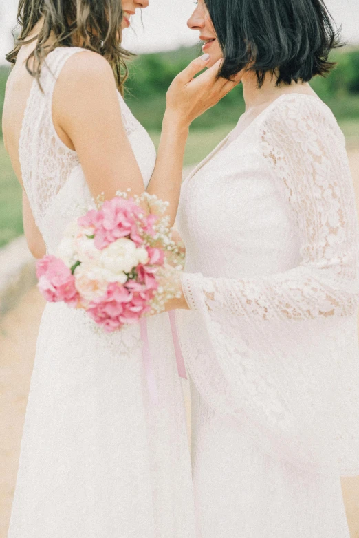 two women who are wearing dresses talking