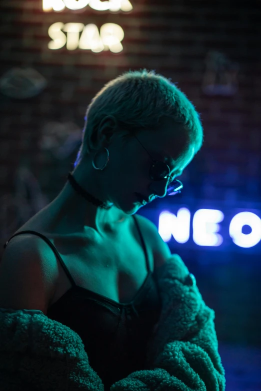 a person with their headphones on while standing in front of a neon sign