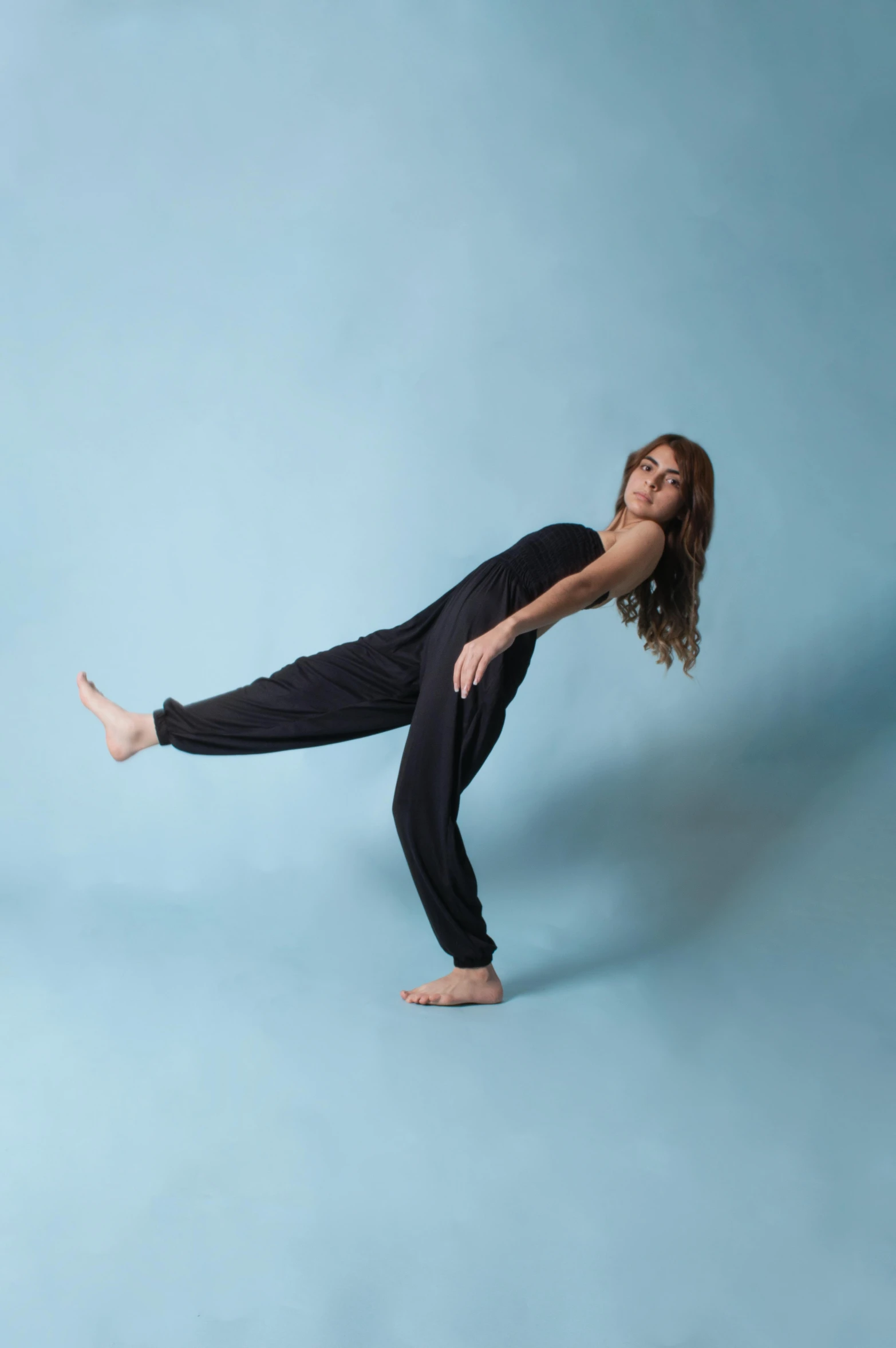 woman posing with one leg spread out while holding the other