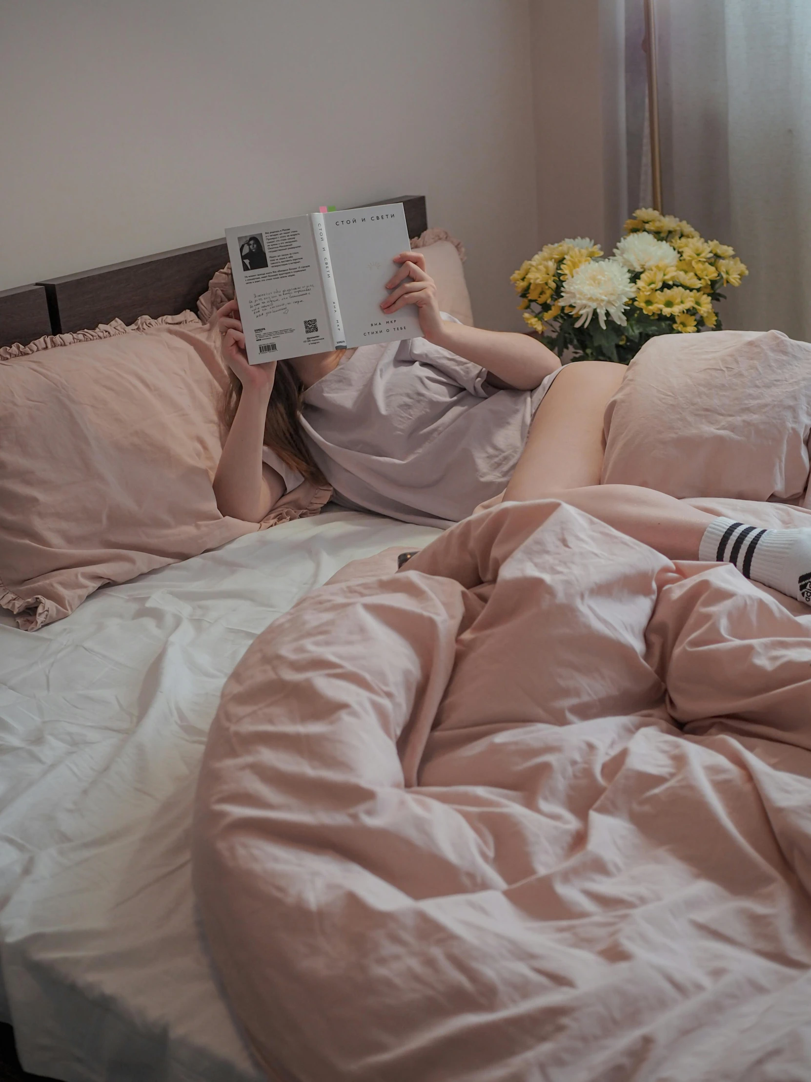 woman lying in bed reading a book about her life