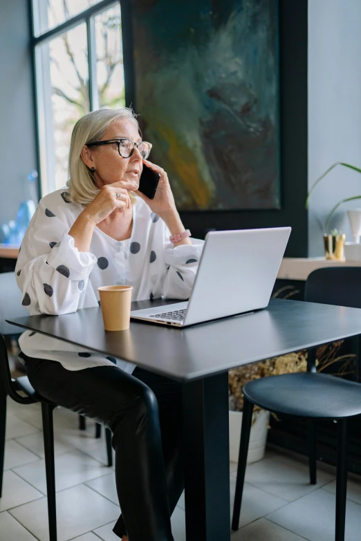 a woman on a laptop talking on the phone