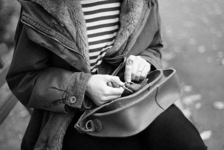 a young lady holds her hand in her purse