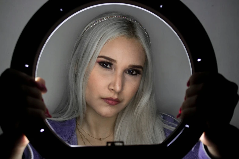 a woman with long hair looks at herself in the mirror