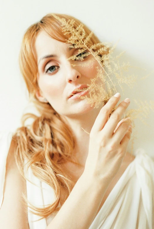 a woman with blonde hair holding her hands together