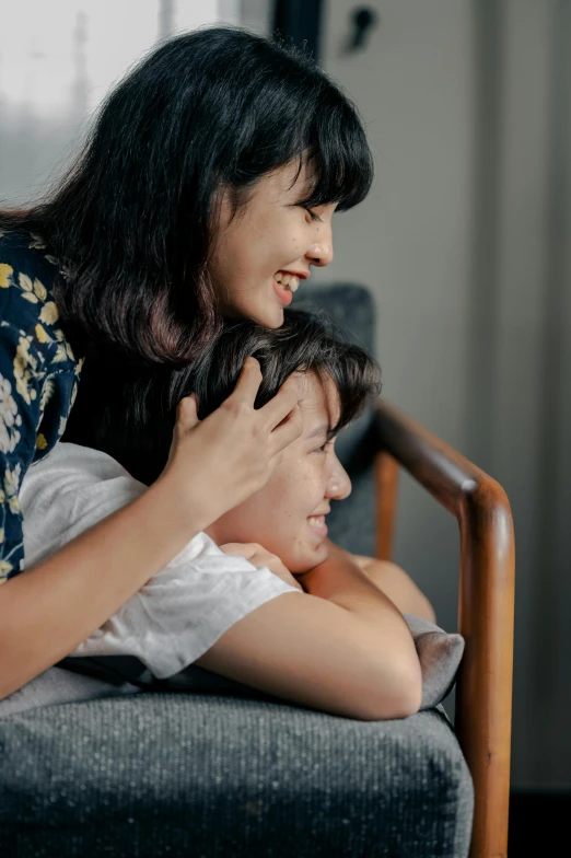 an adult female hugs and hugs the face of a child