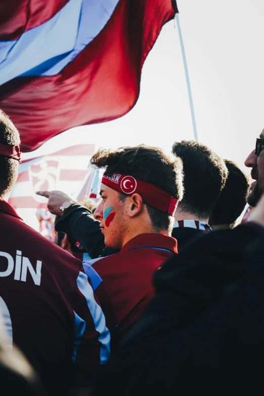 a group of people standing around each other holding onto red flags