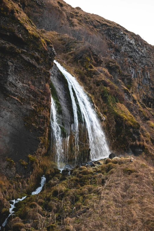 waterfall and trail going up a mountain in winter