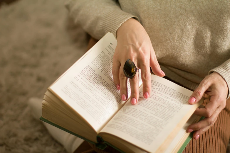 a woman holding onto a book with an owl in it