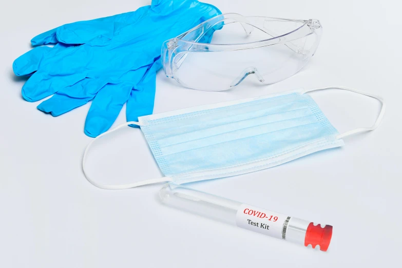 surgical masks, sterile gloves and a safety goggles sitting on top of a table