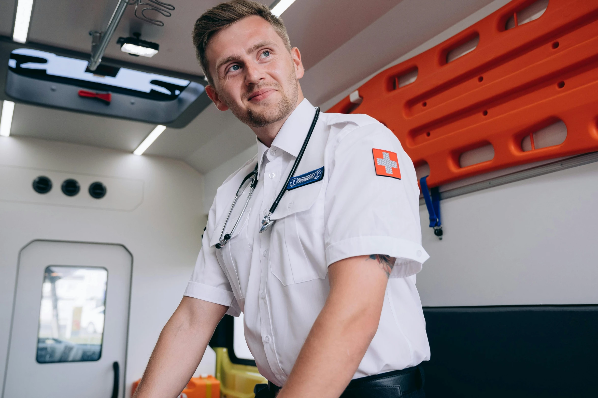 a male medical professional is wearing an orange and white uniform