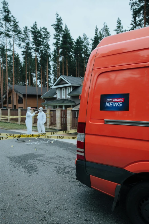 two large fake ghost statues in the background behind a red van