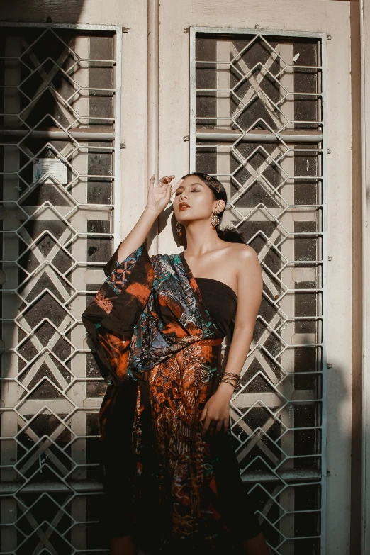 a woman in an orange and black dress is standing