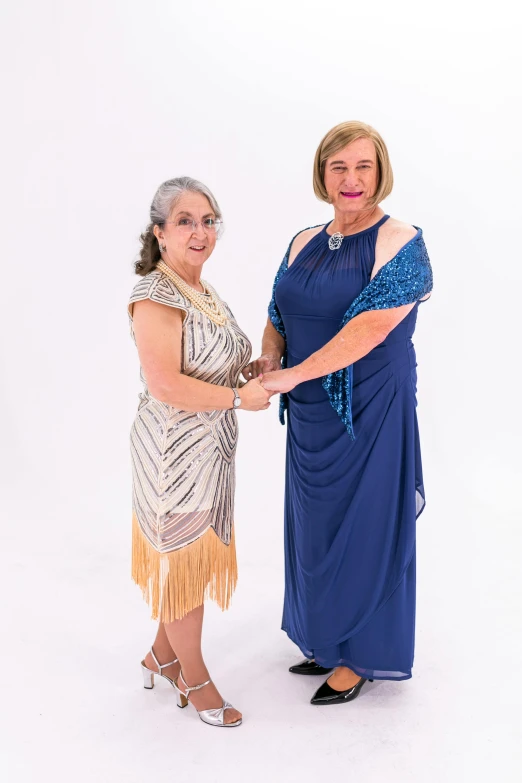 two women pose for the camera in evening wear