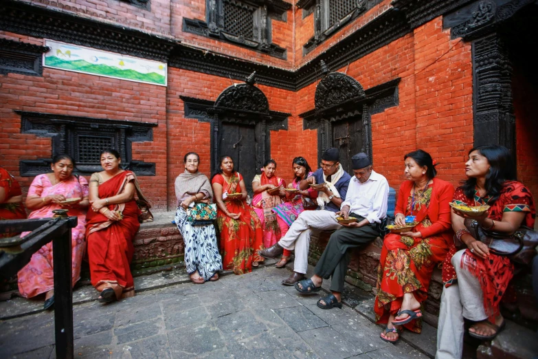 a group of people are sitting on the street