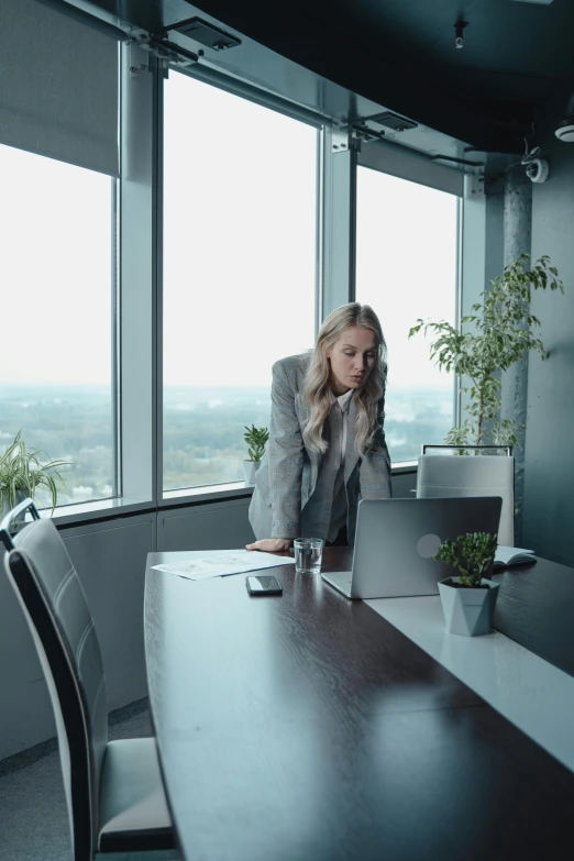 a woman sitting in front of a laptop at a table