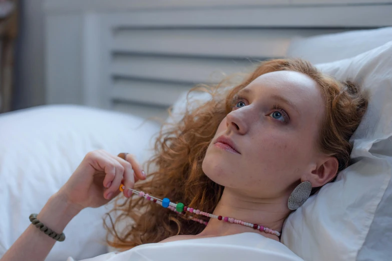 a woman lying in bed while holding a toothbrush