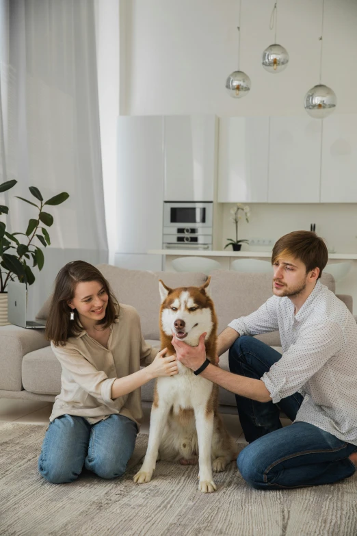 two people kneeling down with their dog